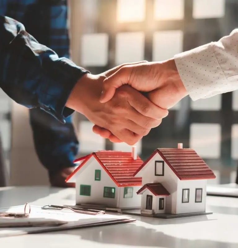 Professional handshake over house models